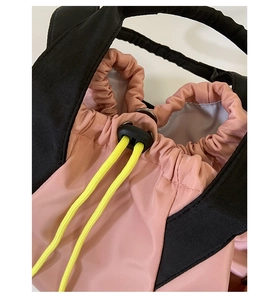 Detail of pink and black nylon drawstring closure with yellow cords and metal rings