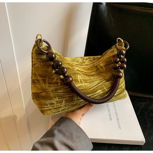 Detail of vintage beaded handle and olive green bamboo leaf velvet texture on the bag