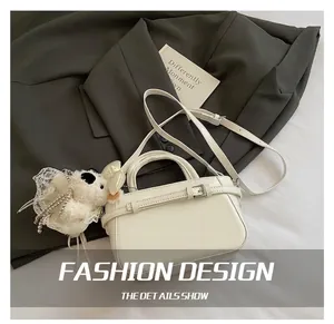 Détail du sac seau blanc avec boucle de ceinture et charmant pendentif chien peluche