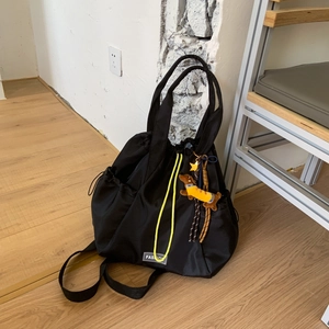 Detail of waterproof nylon drawstring backpack with neon yellow cords and dog pendant