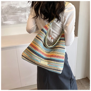 Detail of colorful striped crochet shoulder bag showing woven texture and bead tassel