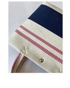 Detail shot of tricolor striped canvas tote bag with visible stitching and metal rivet