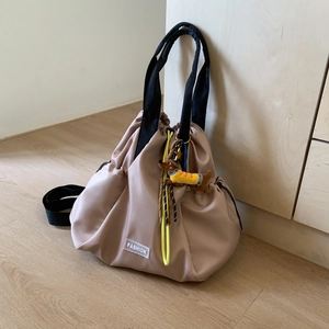 Detail of waterproof nylon drawstring backpack with cute plush dachshund charm