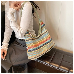 Close-up of rainbow striped woven hobo bag with wide green shoulder strap and colorful beads