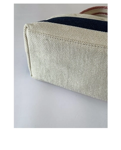 Detailed view of the striped canvas tote bag showing high-quality bottom stitching