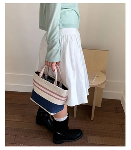 Chic striped canvas tote bag in cream and red, styled with navy base for casual daily use
