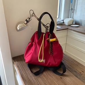 Close-up of deep red nylon drawstring backpack with a cute dachshund puppy charm