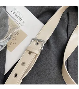 Dettaglio della tracolla regolabile in pelle beige con fibbia argento su borsa a spalla
