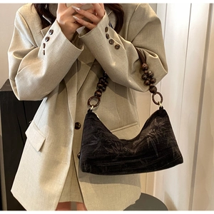 Detail of retro black beaded handbag with bamboo pattern and wooden bead strap on shoulder