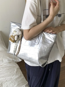Silver metallic crocodile pattern tote bag with a cute plush bear charm for daily commute