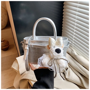 Détail du sac seau argenté avec texture craquelée et charmant pendentif ours blanc