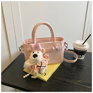 Détail du sac seau rose clair en similicuir mat avec pendentif ours en peluche mignon