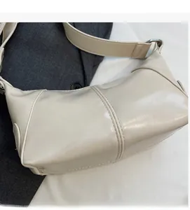 Dettaglio della borsa in pelle PU crema con doppie cuciture rifinite e consistenza morbida