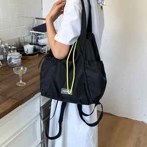 Detail of black nylon drawstring tote bag with neon accents and FASHION logo tag