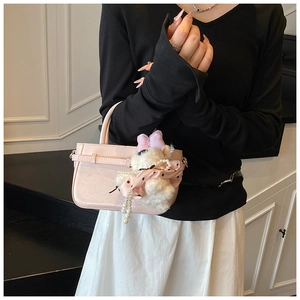 Gros plan du sac seau en cuir rose avec un charmant ours en peluche et perles