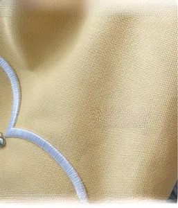 Vue macro du tissu en toile jaune avec des détails de surpiqûres brodées blanches