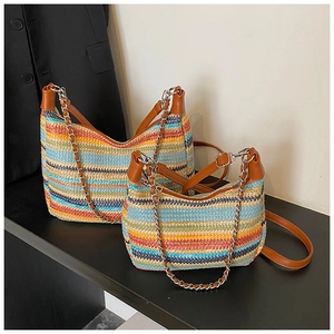 Detailed texture of multi-color striped woven beach bag with leather straps and chain