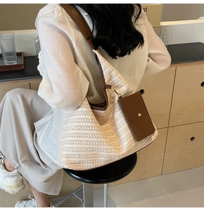 Detail of minimalist straw tote bag with brown leather strap and detachable mini pouch