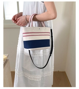 Close-up of canvas striped tote bag with red stripes and navy blue straps detail