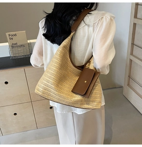 Close-up of straw woven tote with leather piping and matching detachable coin purse charm