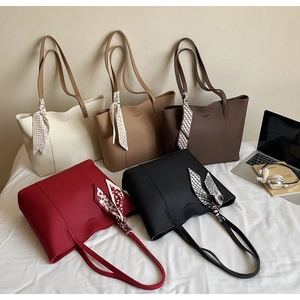 Detailed view of five colored tote bags in lychee grain faux leather with silk scarves