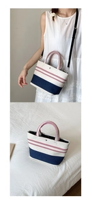 Detail view of canvas striped tote bag with red handles and blue contrast base
