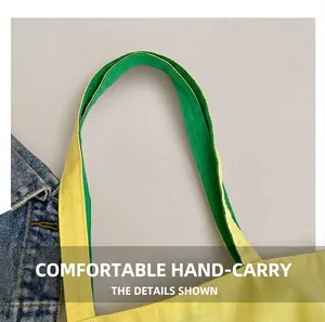 Détail de la poignée en toile jaune avec doublure à carreaux verts et coutures de précision