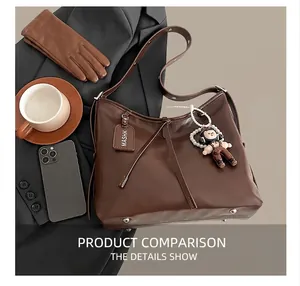 Detailed close-up of dark brown leather tote bag with pearl doll charm and metal feet