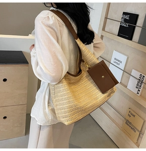 Detail of a beige straw tote bag with brown leather straps and a matching coin purse