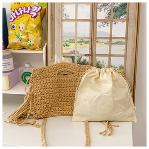 Detail view of cotton crochet shoulder bag with bohemian tassels and inner drawstring pouch