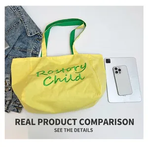 Vue à plat d'un sac cabas en toile jaune avec broderie verte, montré à côté d'un iPad pour taille