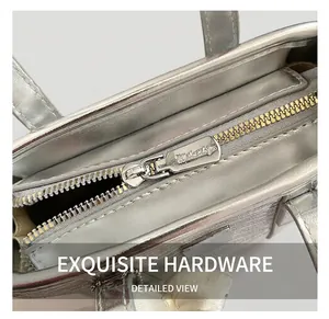 Detail of silver bucket bag showing premium golden metal zipper and branded puller