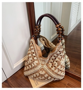 Detailed close-up of bohemian woven tote featuring floral patterns and wooden bead handles