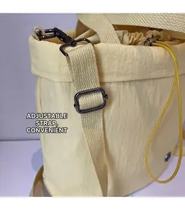 Detail of adjustable canvas strap with durable gunmetal hooks on a nylon bucket bag