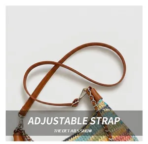 Detail of multi-color woven straw bag featuring brown leather strap and chain accent