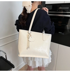 Détail du sac cabas crème avec ours et lapins en relief et un pendentif mignon attaché
