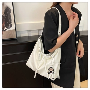 White leather hobo tote bag with astronaut charm and spacious interior for daily commute