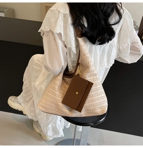 Close-up of beige woven shoulder bag with a brown leather strap and mini pouch charm