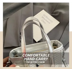 Detailed close-up of the silver bucket bag with textured finish and top metal handles