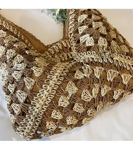 Detail of khaki and cream crochet pattern on large woven straw tote bag for beach vacations
