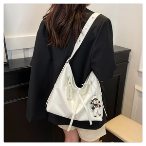 White large-capacity Hobo bag with wide shoulder strap and black astronaut charm