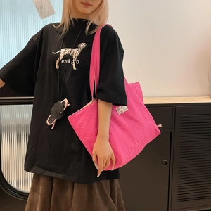 Vue détaillée du sac cabas rose tissé porté avec un t-shirt noir imprimé dalmatien