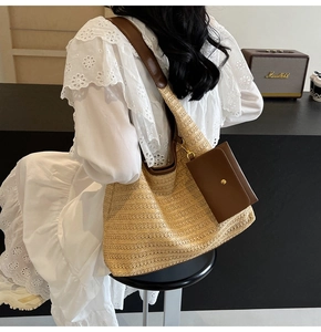 Detail of woven straw tote bag with brown leather strap and detachable mini envelope pouch