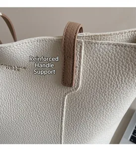 Close-up of reinforced stitching on lychee grain leather tote bag with fashion lettering