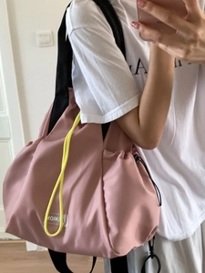 Pink waterproof nylon drawstring backpack with neon yellow cord and fashion label