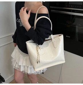 Détail du sac cabas blanc gaufré avec motif d'ours et bandoulière de transport