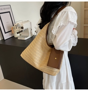 Detailed shot of beige straw tote bag with brown leather strap and functional pouch