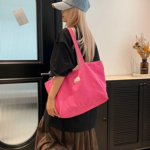 Détail du sac cabas fuchsia avec texture gaufrée et bandoulière de haute qualité