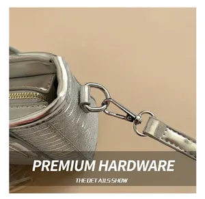 Detail view of silver textured bucket bag with polished metal hooks and strap connectors
