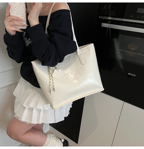 Détail du sac cabas blanc crème avec motifs de dessins animés gaufrés et gland tissé